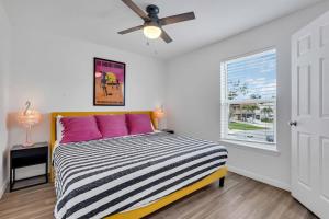 ブレーデントンにあるBradenton Stay, Private Pool, HotTub, Priv Terraceのベッドルーム1室(ピンクの枕と天井ファン付きのベッド1台付)