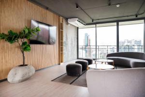 a living room with a couch and a tv at Enjoy the Space 2BR 2BA Parque Araucano Sector in Santiago