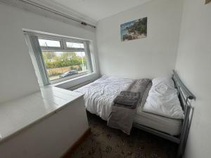 a small bedroom with a bed and a window at Rainbow house in Killingbeck