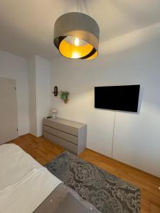 a bedroom with a bed and a flat screen tv at Gemütliche 2-Raum-Wohnung in Leipzig