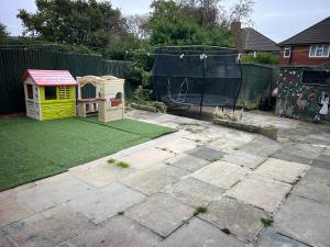a backyard with a dog house and a playset at Rainbow house in Killingbeck
