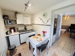 a kitchen with a table with a table cloth on it at Le petit studio cosy - 30m2 in Le Breuil