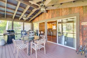 a screened in porch with a table and chairs at Waterside Anglers Heaven Crooked River Fish Camp in Yankeetown