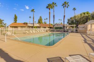 a large swimming pool with chairs and palm trees at Patio, Grill and Pool Access Palm Desert Retreat! in Palm Desert