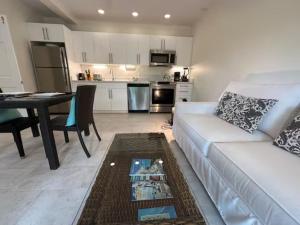 a living room with a white couch and a kitchen at Karana 4 Bedroom in Long Bay Hills