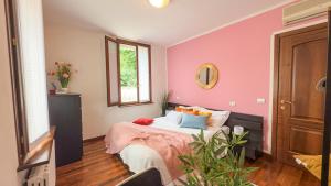 a bedroom with a bed with a pink wall at Residenza Sirtori free parking in Verona +57 photos