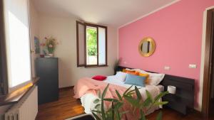 a bedroom with a pink wall and a bed at Residenza Sirtori free parking in Verona