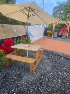 a picnic table with an umbrella on a patio at Villa Mi casita el paraiso costero in Aguada