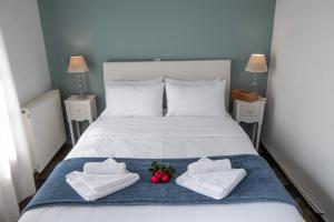 a bedroom with a bed with two towels and two roses at Mountain Bell in Kalívia