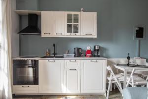 a kitchen with white cabinets and a table with chairs at Mountain Bell in Kalívia