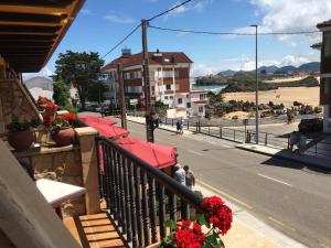 a balcony with red umbrellas on a city street at Hotel La Huerta in Isla