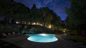 a swimming pool at night with chairs and trees at Villa Val Lemme - Albergo Ristorante in Francavilla Bisio