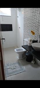 a bathroom with a toilet and a sink at JF's Refuge in Pirapora