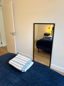 a bedroom with a blue bed and a mirror at Modern Flat In Penge - 3 person in Elmers End