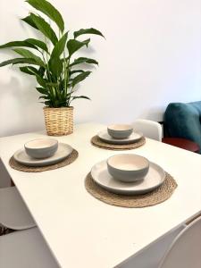 a table with three plates and a plant on it at Modern Flat In Penge - 3 person in Elmers End +9 photos