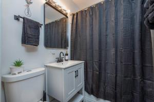 a bathroom with a toilet sink and a shower curtain at Cottingham Cottage in Zion +22 photos