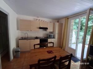 a kitchen with a wooden table with chairs and a window at Gites Villa Robinson in Mazamet