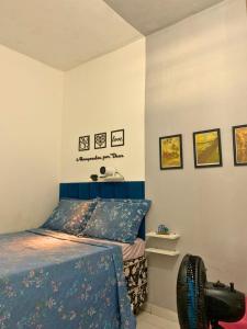 a bedroom with a bed with a blue head board at Quarto privativo La Paz in Aracaju