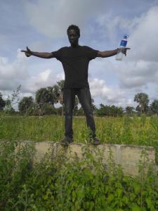 a man standing on a wall holding a bottle of water at My home 