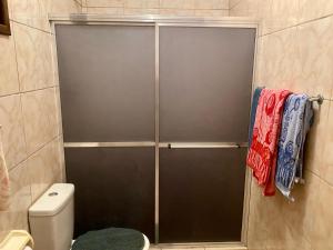 a shower door in a bathroom with a toilet at Casa Pôr do Sol Angra in Angra dos Reis