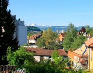 a view of a city with buildings and trees at Room near the station Bolligen in Bolligen