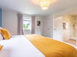 Un dormitorio con una cama grande con una manta amarilla. en 2 Bed in St. Mellion 87709, en St Mellion 18 fotos más