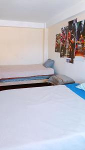 two beds in a room with posters on the wall at Casa hospedaje Palomino in Abancay