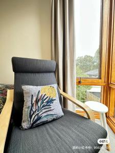 a chair with a pillow sitting next to a window at 1B1B Private Studio near Doncaster Westfield in Doncaster