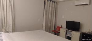 a bedroom with a bed and a flat screen tv at Pousada horbis in Guarabira