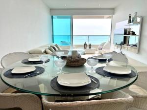 CarolinaBeach front Ocean view, pool Family Apt Salinas的用餐室配有玻璃桌和椅子