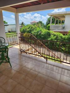 een balkon met een leuning en een tafel en stoel bij Chambre lumineuse chez L'habitant in Le Lamentin