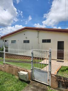 een hek voor een wit huis bij Chambre lumineuse chez L'habitant in Le Lamentin