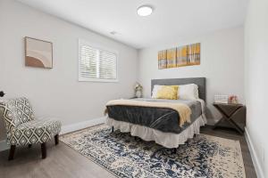 un dormitorio con una cama y una silla en 7 Min walk to Golden Belt - 4 Min Drive to Downtown - 7 to Duke, en Durham