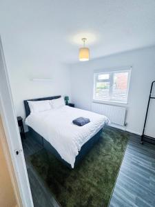 a bedroom with a large white bed in a room at Modern 2-Bed w Parking & Garden in Woolwich