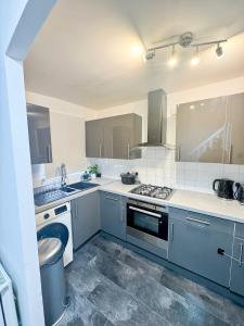 a kitchen with a sink and a stove at Modern 2-Bed w Parking & Garden in Woolwich
