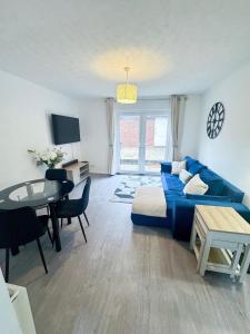 a living room with a blue couch and a table at Modern 2-Bed w Parking & Garden in Woolwich