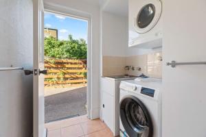 a laundry room with a washer and dryer at The Sand Nook - 2 Bedroom Fishpen Apartment in Merimbula