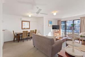 a living room with a couch and a table at The Sand Nook - 2 Bedroom Fishpen Apartment in Merimbula