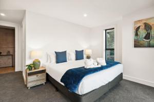 a bedroom with a large bed with two stuffed animals on it at Elevated Tranquility Luxe Lakeview Horizons in Queenstown
