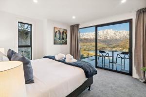 a bedroom with a bed and a balcony with a view at Elevated Tranquility Luxe Lakeview Horizons in Queenstown