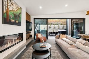 a living room with a couch and a fireplace at Elevated Tranquility Luxe Lakeview Horizons in Queenstown