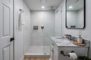 ein weißes Badezimmer mit Dusche und Waschbecken in der Unterkunft The Key Reno'd Historic 1BD 1 Mile to UF & DT in Gainesville