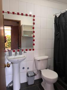 a bathroom with a toilet and a sink at Cabaña 2 habitaciones matrimoniales in Valdivia
