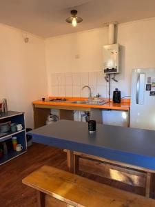 a kitchen with a blue counter top and a refrigerator at Cabaña 2 habitaciones matrimoniales in Valdivia