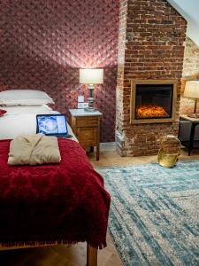 a bedroom with a bed and a fireplace at Lovelace Suites by Threads of Time Hotel Bruges in Bruges