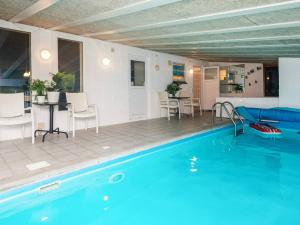 a swimming pool with chairs and a table and a table and a tablektop at 8 person holiday home in Ebeltoft-By Traum in Ebeltoft