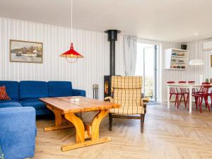 a living room with a blue couch and a table at 6 person holiday home in Augustenborg in Augustenborg +21 photos