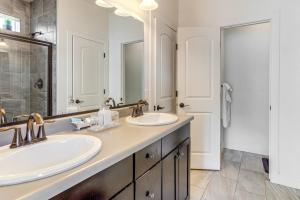 a bathroom with two sinks and a large mirror at Work and Play in Aurora Spacious Home with Yard! in Altura +24 photos