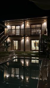 Una casa de noche con una piscina delante de ella. en Pousada Pequeno Oásis Tiradentes, en Tiradentes