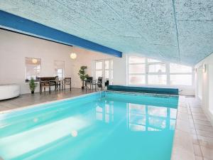 a swimming pool in a house with a table and chairs at 14 person holiday home in Sæby in Sæby